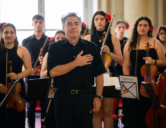 Javier Claudio saluda, con la orquesta al fondo / Bratislava Music Agency